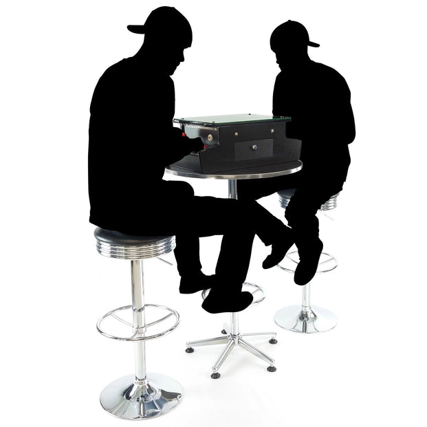 Silhouettes Of Two People Playing A Tabletop Arcade Machine On Stools
